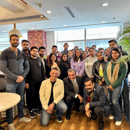 Large group of FinEdge team members posing together in the office lounge area.