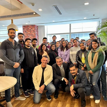 Large group of FinEdge team members posing together in the office lounge area.
