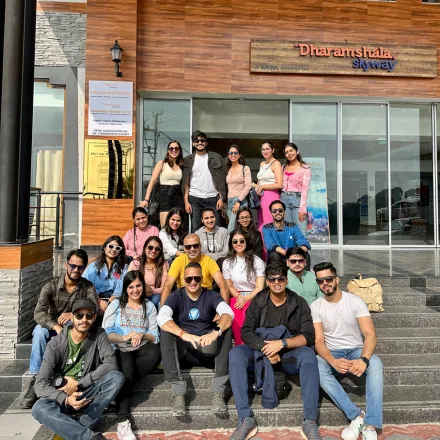 FinEdge team group photo on the steps outside the Dharamshala Skyway building during a trip.