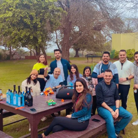 FinEdge team members gathered around a picnic table outdoors with refreshments.
