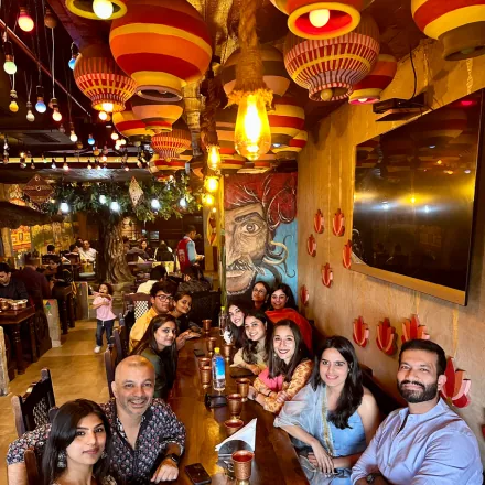 Team members seated together at a colourfully decorated restaurant with hot-air-balloon themed lanterns.