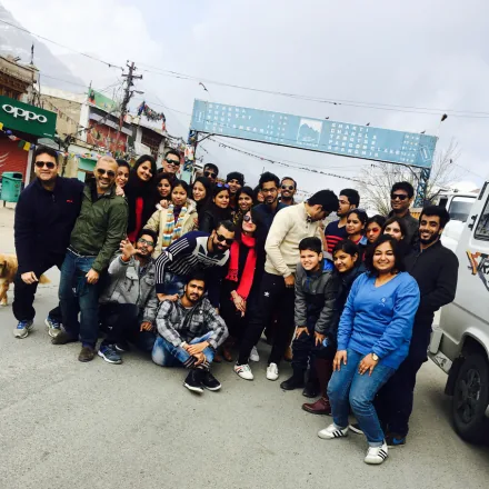 Large group of FinEdge team members and families posing on a street during a trip.