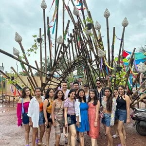 Group of FinEdge team members posing in front of a large wooden art installation.