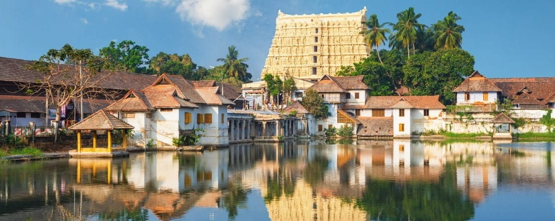 View of Padmanabhaswamy Temple and surrounding traditional houses reflected in a serene water tank in Thiruvananthapuram.