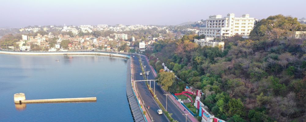 Aerial view of Bhopal's Upper Lake and surrounding cityscape, capturing the scenic blend of nature, roads, and urban planning.